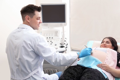 Young pregnant woman undergoing ultrasound scan in clinic