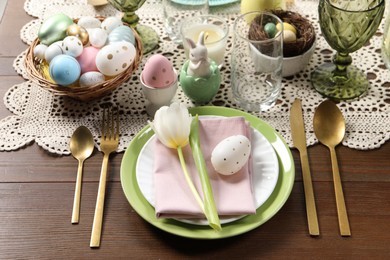 Photo of Festive table setting with painted eggs. Easter celebration