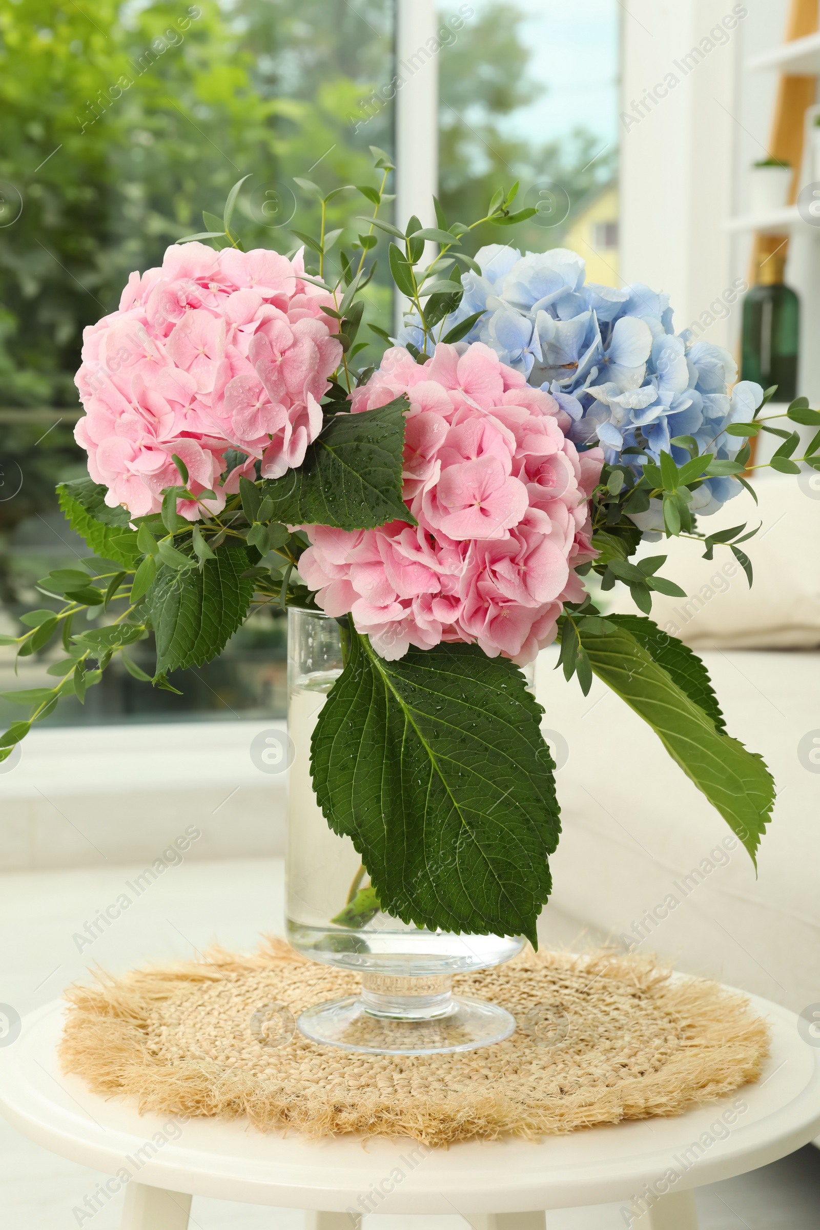 Photo of Bouquet with beautiful hortensia flowers on table in living room