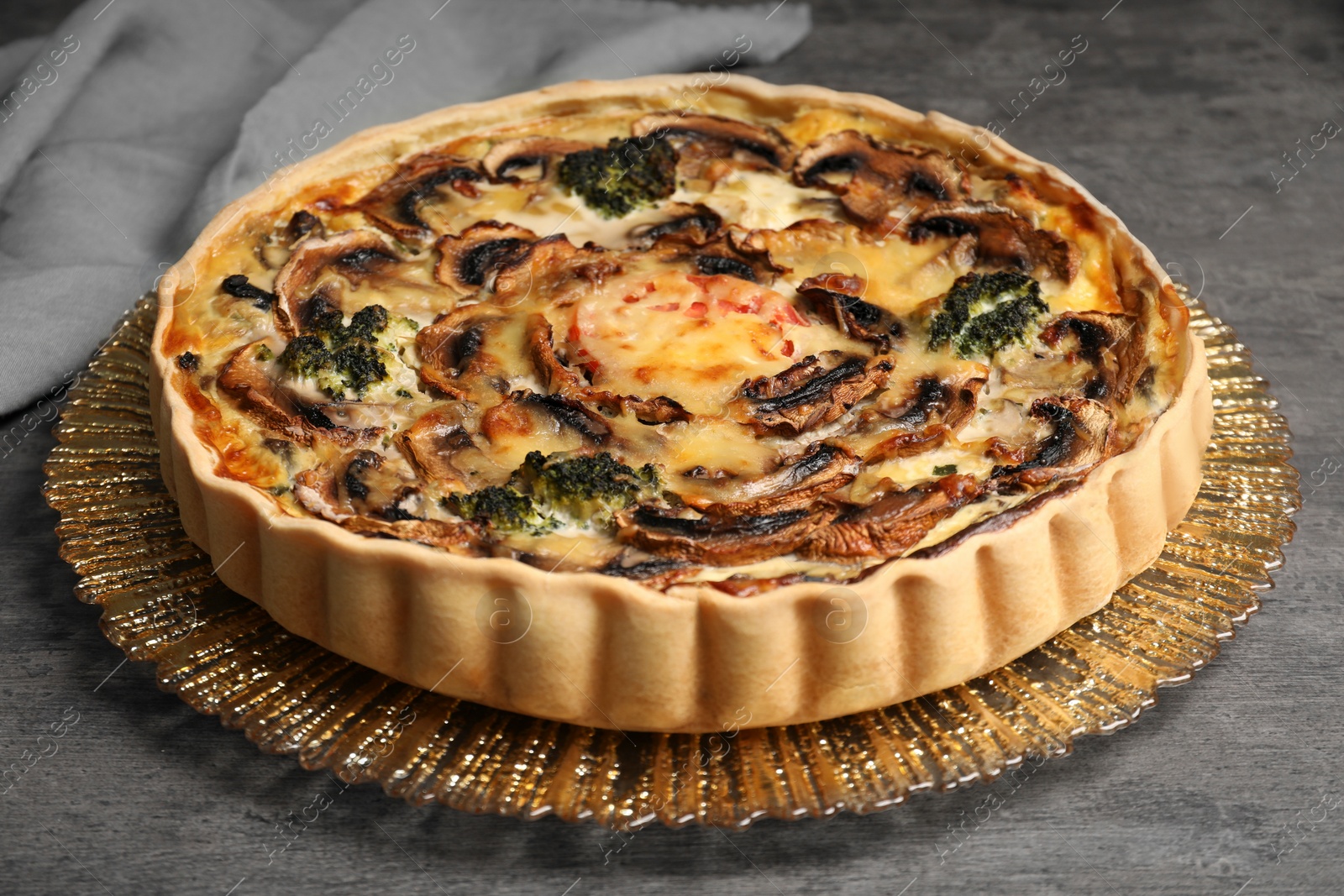 Photo of Delicious quiche with mushrooms on dark grey table, closeup