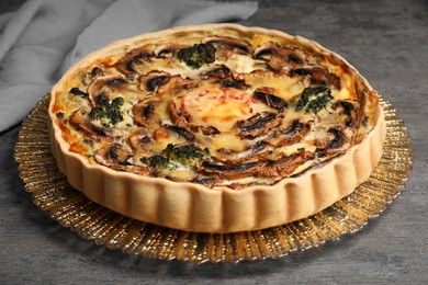 Delicious quiche with mushrooms on dark grey table, closeup