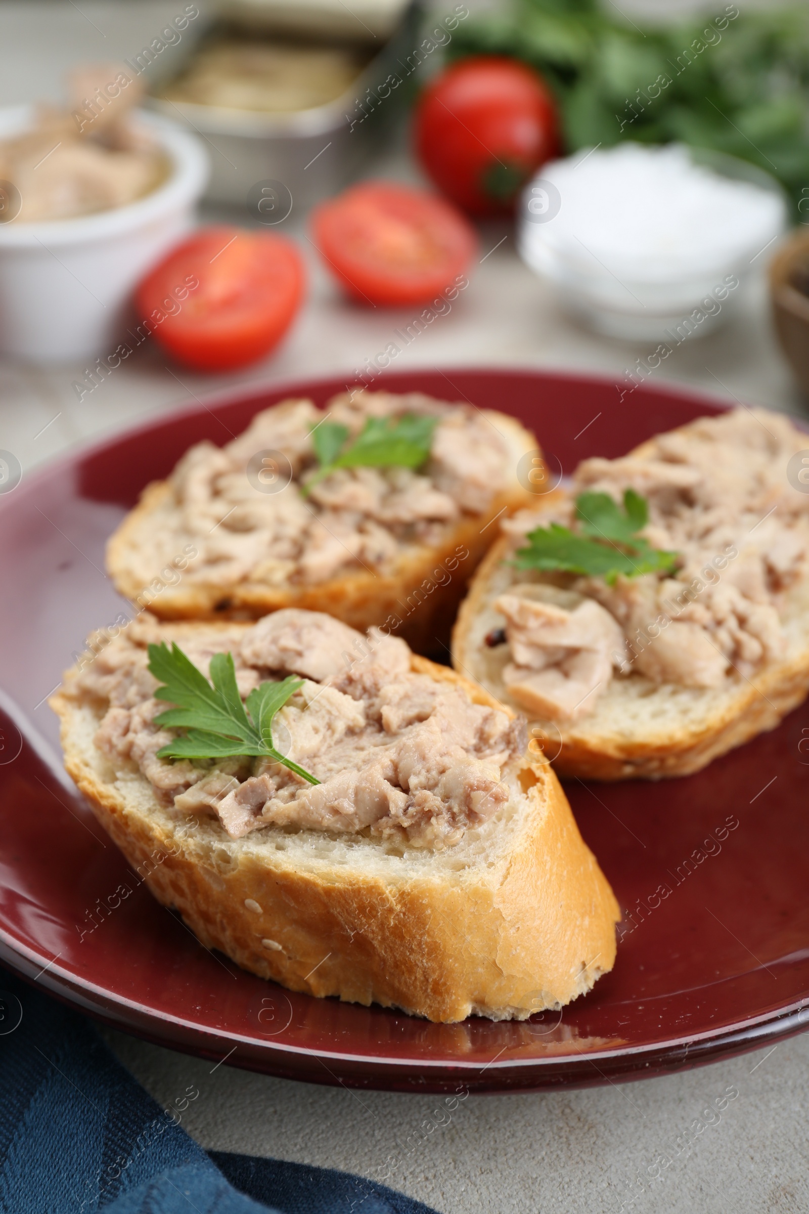 Photo of Tasty sandwiches with cod liver and parsley on light grey table