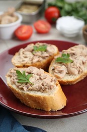 Photo of Tasty sandwiches with cod liver and parsley on light grey table