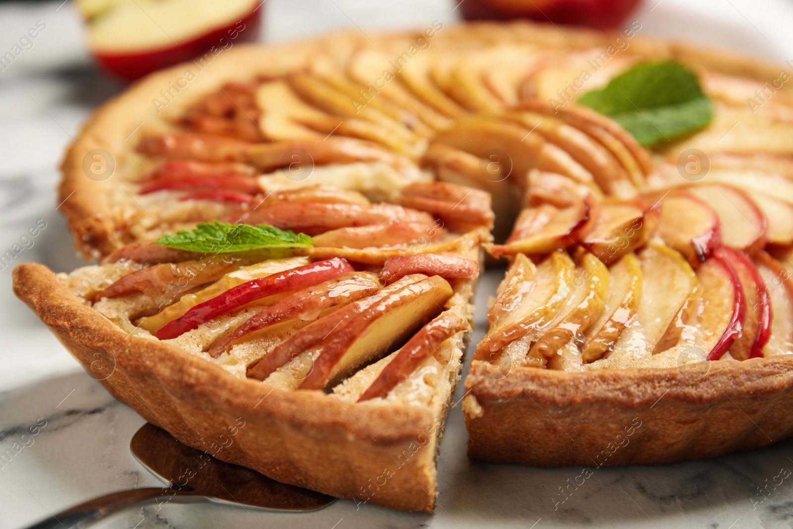 Photo of Slice of delicious apple pie on white marble table, closeup