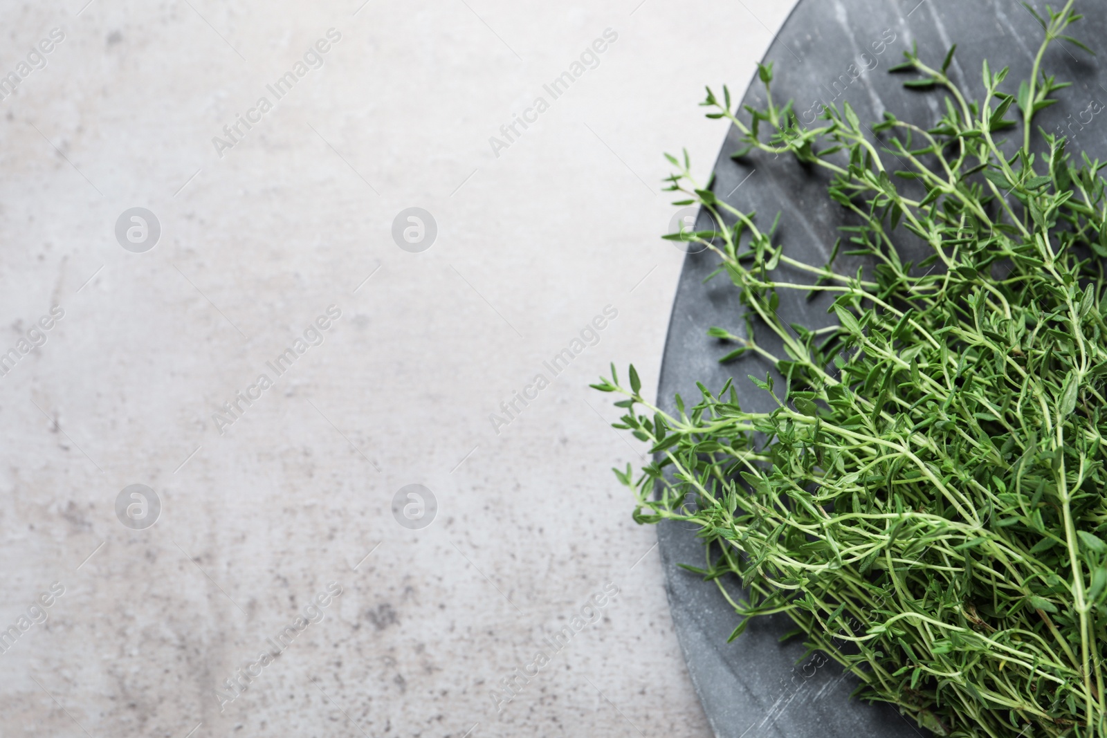 Photo of Bunch of aromatic thyme on light table, top view. Space for text