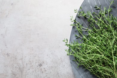 Photo of Bunch of aromatic thyme on light table, top view. Space for text