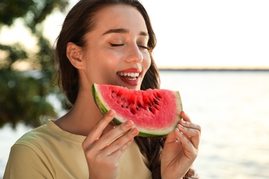 Beautiful young woman with watermelon near river