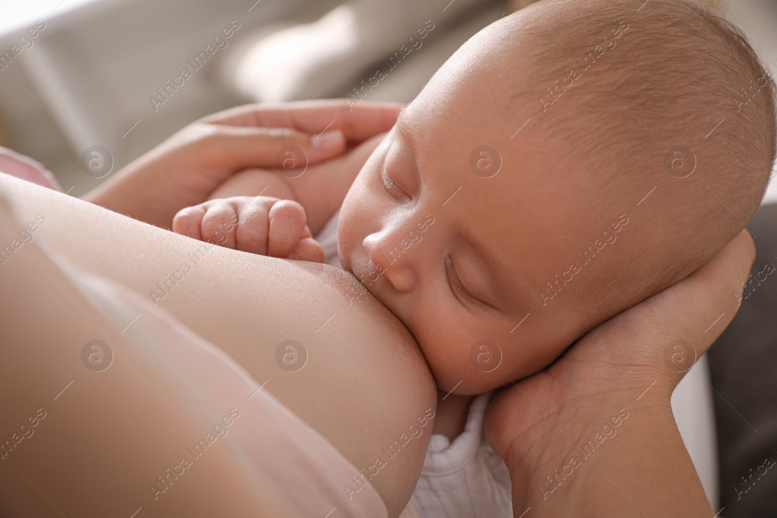 Photo of Woman breastfeeding her cute little baby, closeup