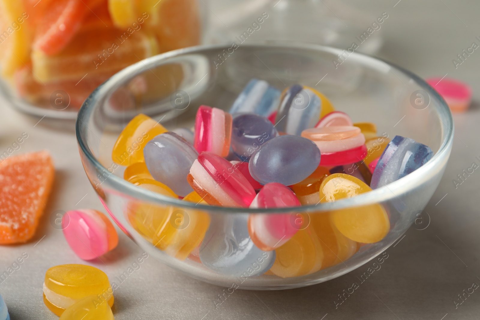 Photo of Tasty colorful sweets on light grey table, closeup