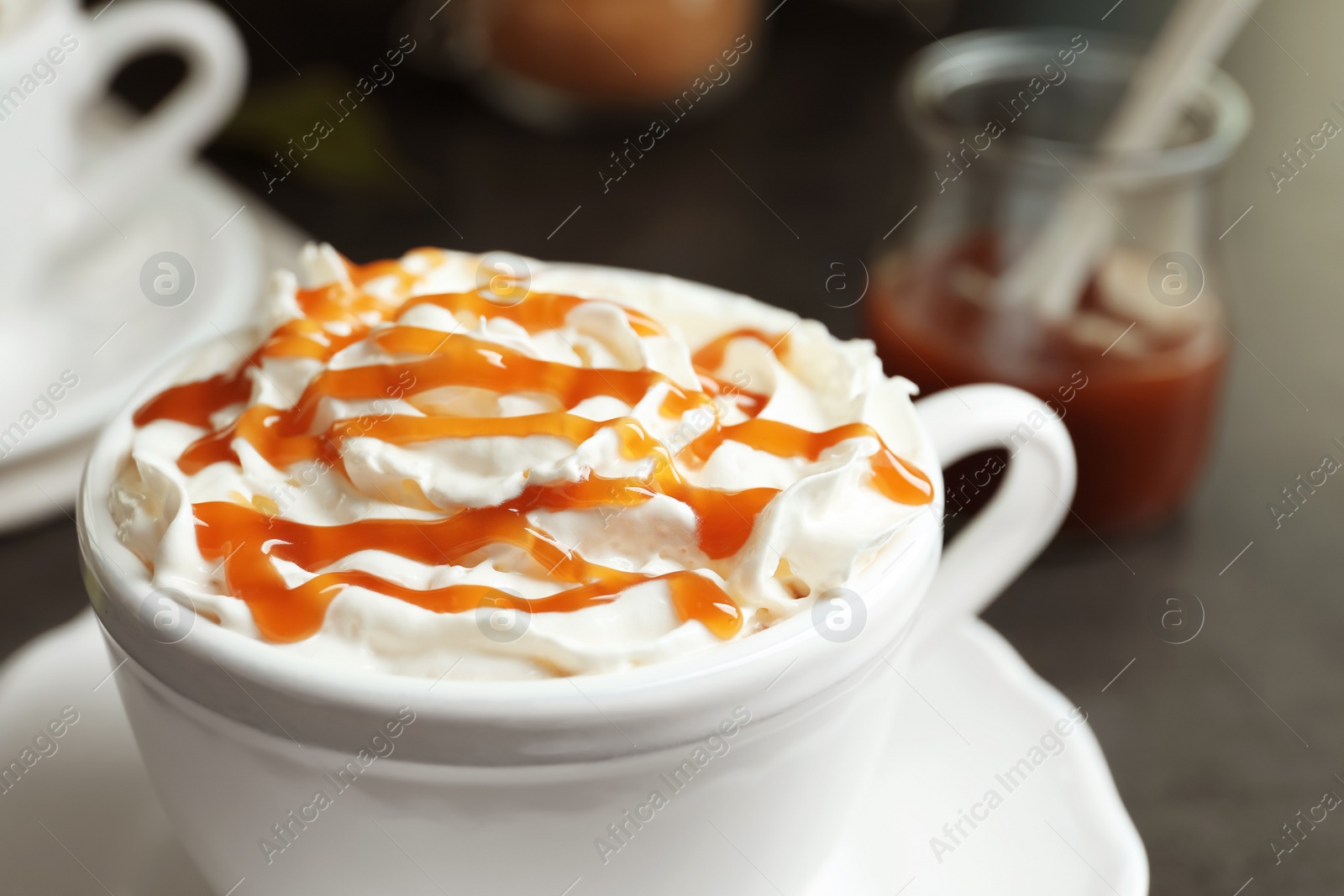 Photo of Cup of coffee with caramel topping on table