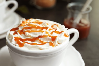 Photo of Cup of coffee with caramel topping on table