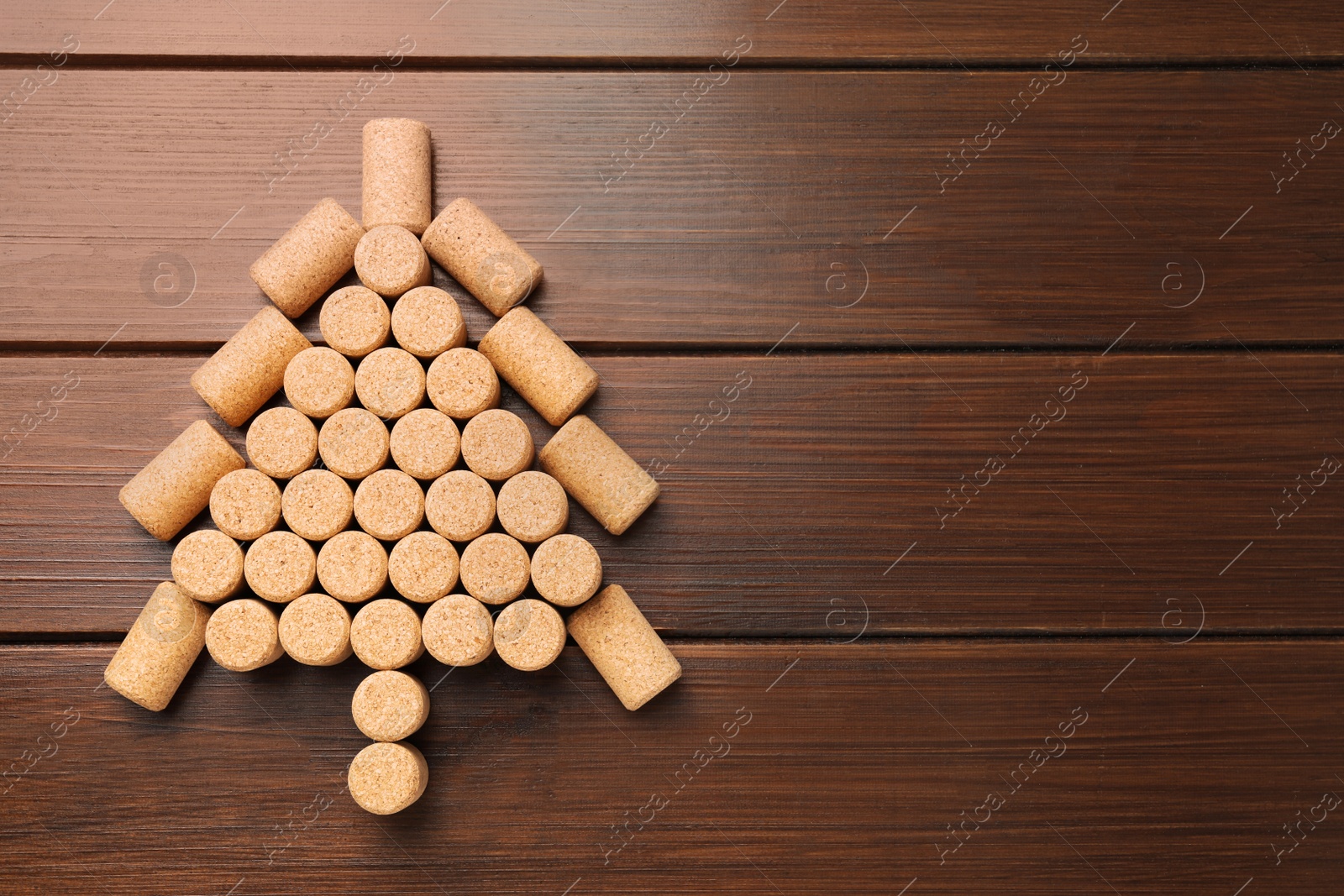 Photo of Christmas tree made of wine corks on wooden table, top view. Space for text