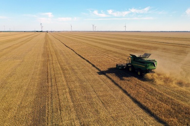 Photo of Modern combine harvester working in field on sunny day. Agriculture industry