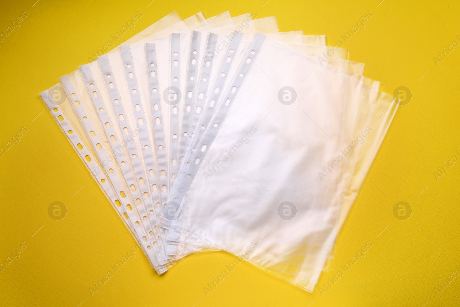 Photo of Punched pockets on yellow background, flat lay