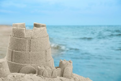 Sand castle on ocean beach, closeup with space for text. Outdoor play