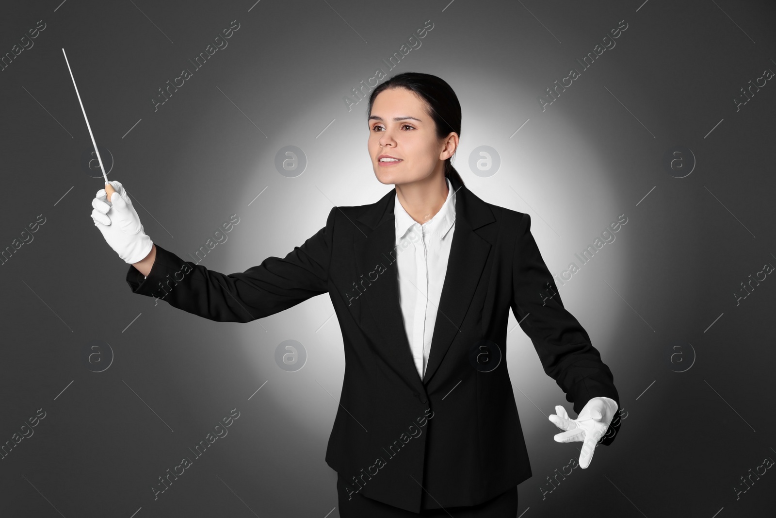 Photo of Professional conductor with baton on grey background