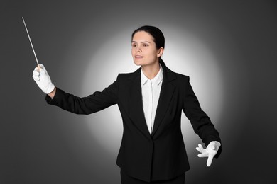 Photo of Professional conductor with baton on grey background