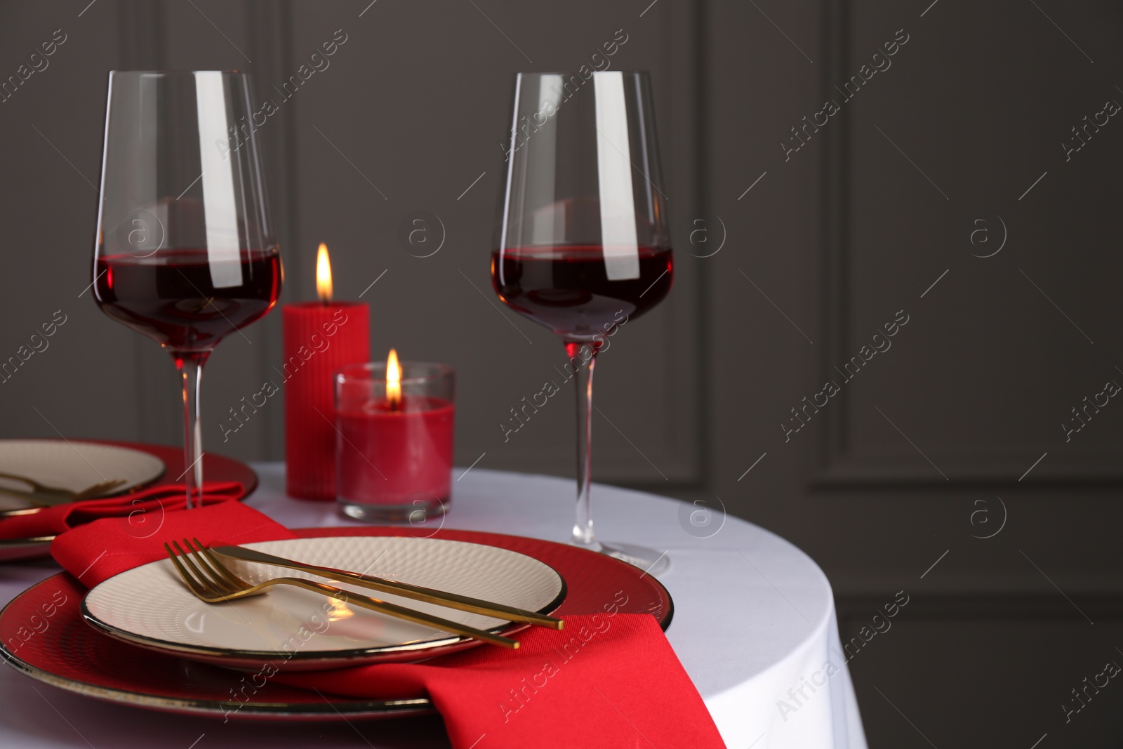 Photo of Place setting with candles on white table, space for text. Romantic dinner