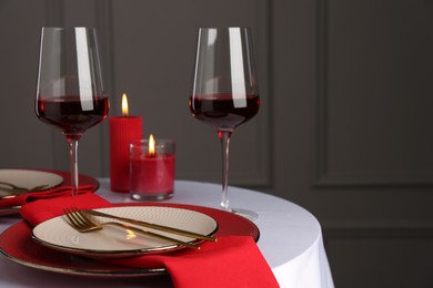 Place setting with candles on white table, space for text. Romantic dinner