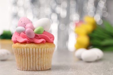 Photo of Tasty decorated Easter cupcake on grey table, closeup. Space for text