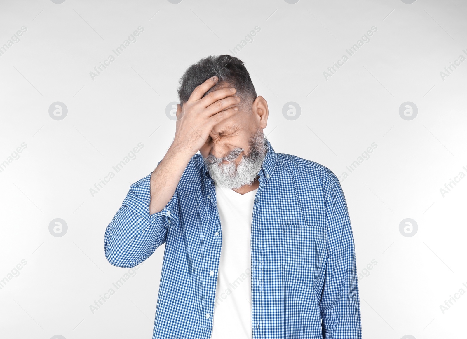 Photo of Man suffering from headache on light background