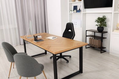 Photo of Stylish director's workplace with wooden table and comfortable armchairs in office. Interior design