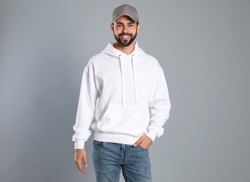 Photo of Portrait of young man in sweater on grey background. Mock up for design