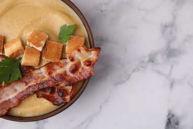 Photo of Delicious lentil soup with bacon and parsley in bowl on light marble table, top view. Space for text