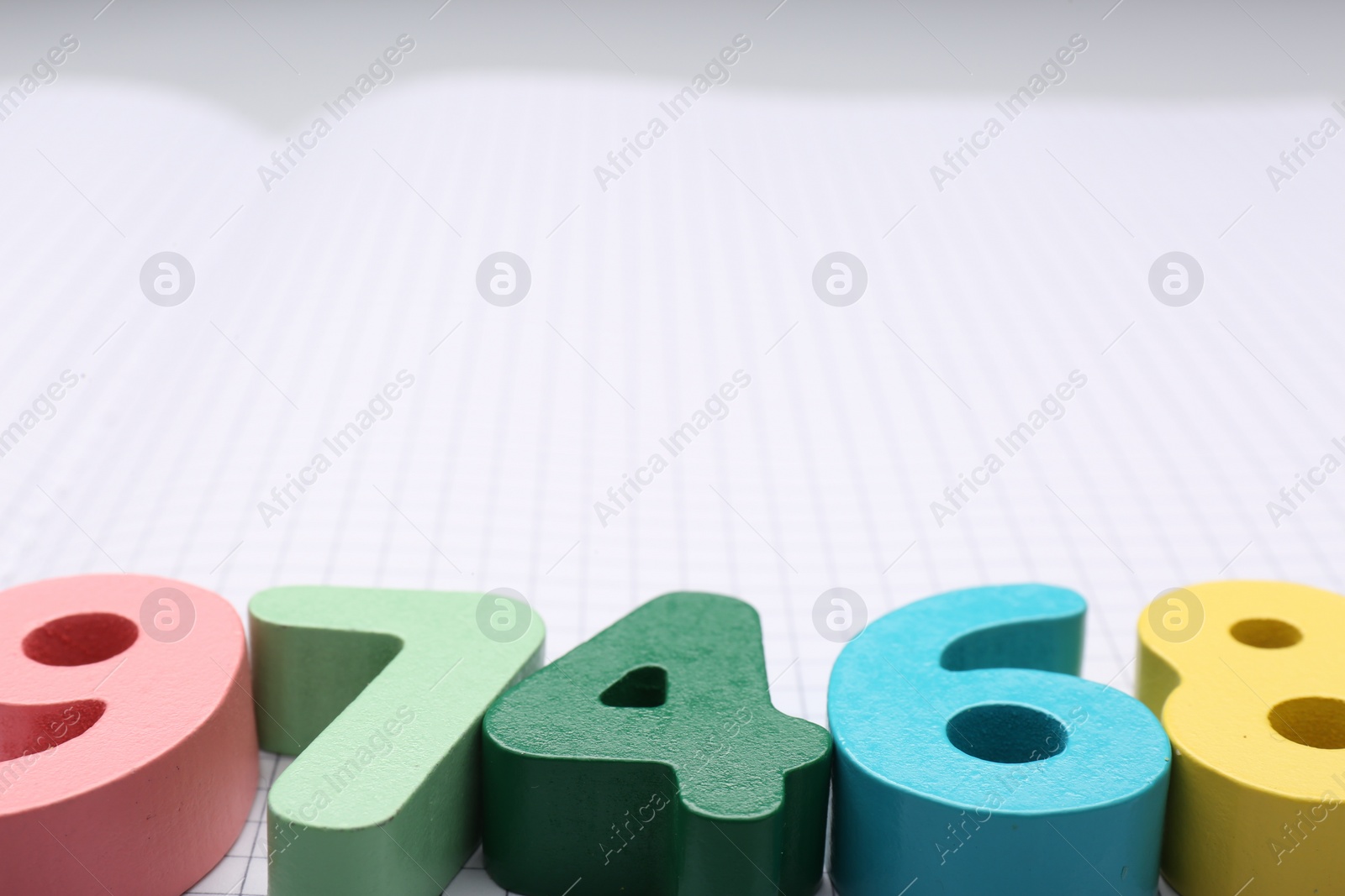 Photo of Colorful numbers on notebook with grid pages. Space for text