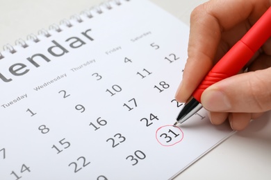 Woman marking date in calendar, closeup. New Year countdown