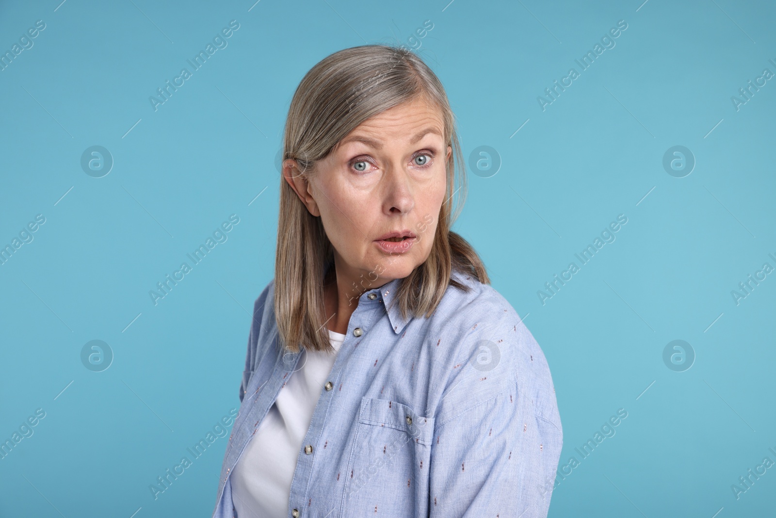 Photo of Portrait of surprised senior woman on light blue background