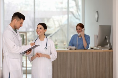 Photo of Doctors working near receptionist while she talking on phone in hospital