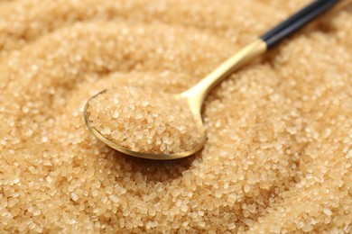 Photo of Spoon on granulated brown sugar, closeup view