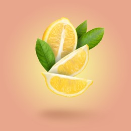 Image of Cut fresh lemon with green leaves falling on pastel coral background