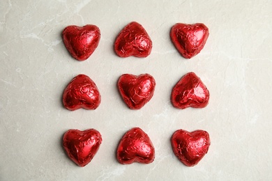 Heart shaped chocolate candies on light grey table, flat lay. Valentine's day treat