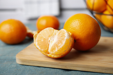 Photo of Fresh ripe tangerines on blue wooden table, closeup