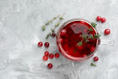 Photo of Delicious cranberry tea with thyme and berries on grey table, flat lay. Space for text