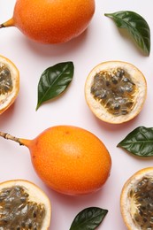 Photo of Delicious ripe granadillas and leaves on white background, flat lay