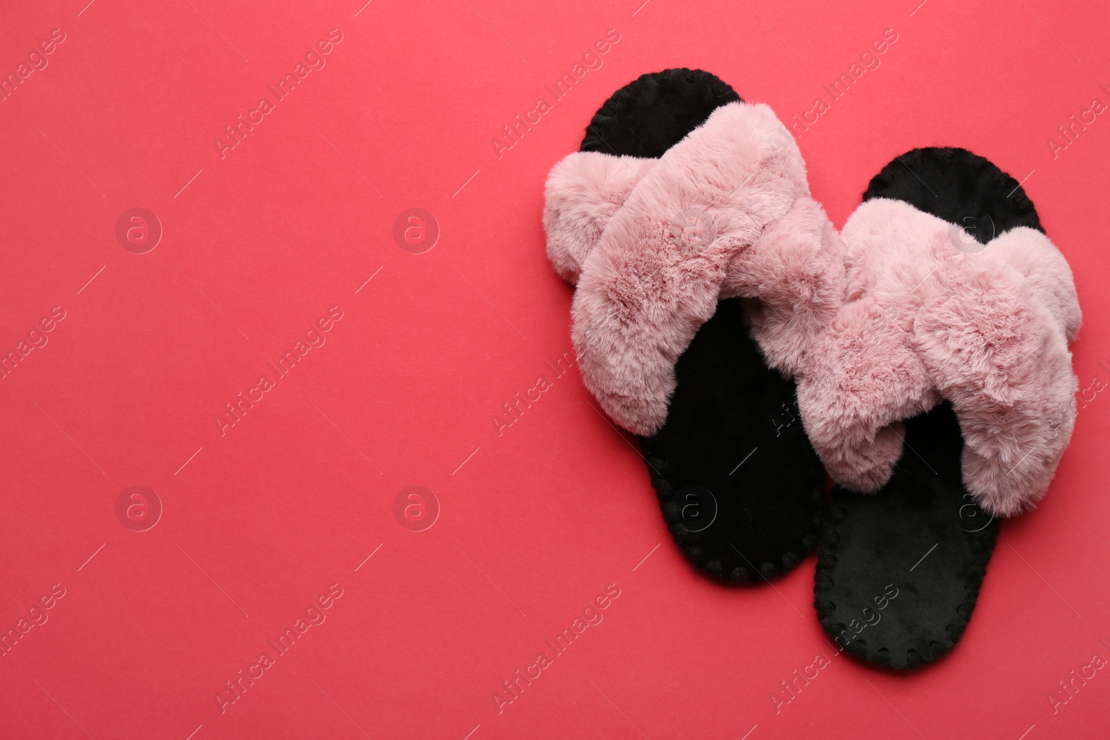 Photo of Pair of soft slippers on red background, flat lay. Space for text