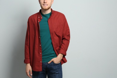 Young man wearing blank t-shirt on light background, closeup. Mockup for design