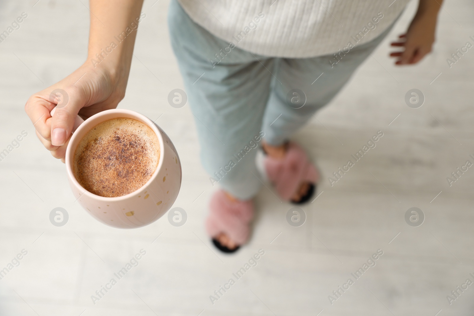Photo of Woman holding cup of coffee indoors, above view