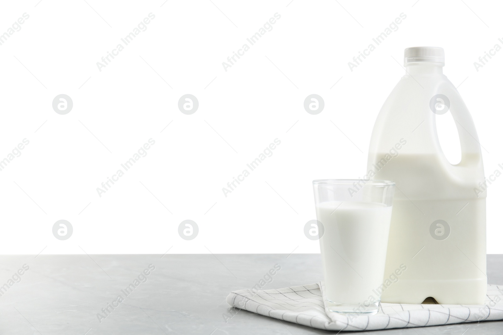 Photo of Gallon bottle of milk and glass on light grey table. Space for text. Space for text