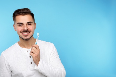 Photo of Young man with toothbrush on color background, space for text. Teeth care