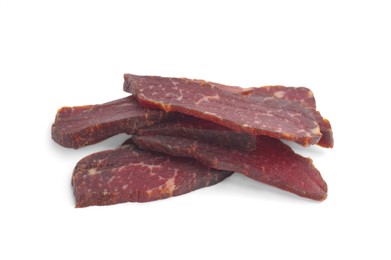 Photo of Pieces of delicious beef jerky on white background