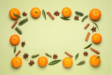 Photo of Frame made of fresh tangerines on light green background, flat lay. Christmas composition with space for text