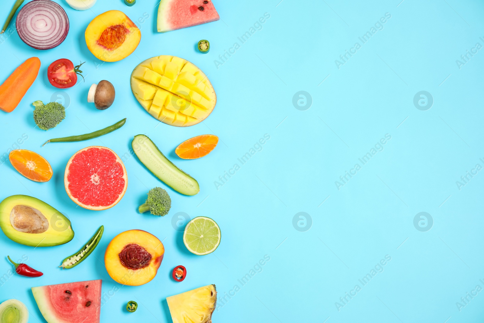 Photo of Flat lay composition with fresh organic fruits and vegetables on light blue background. Space for text