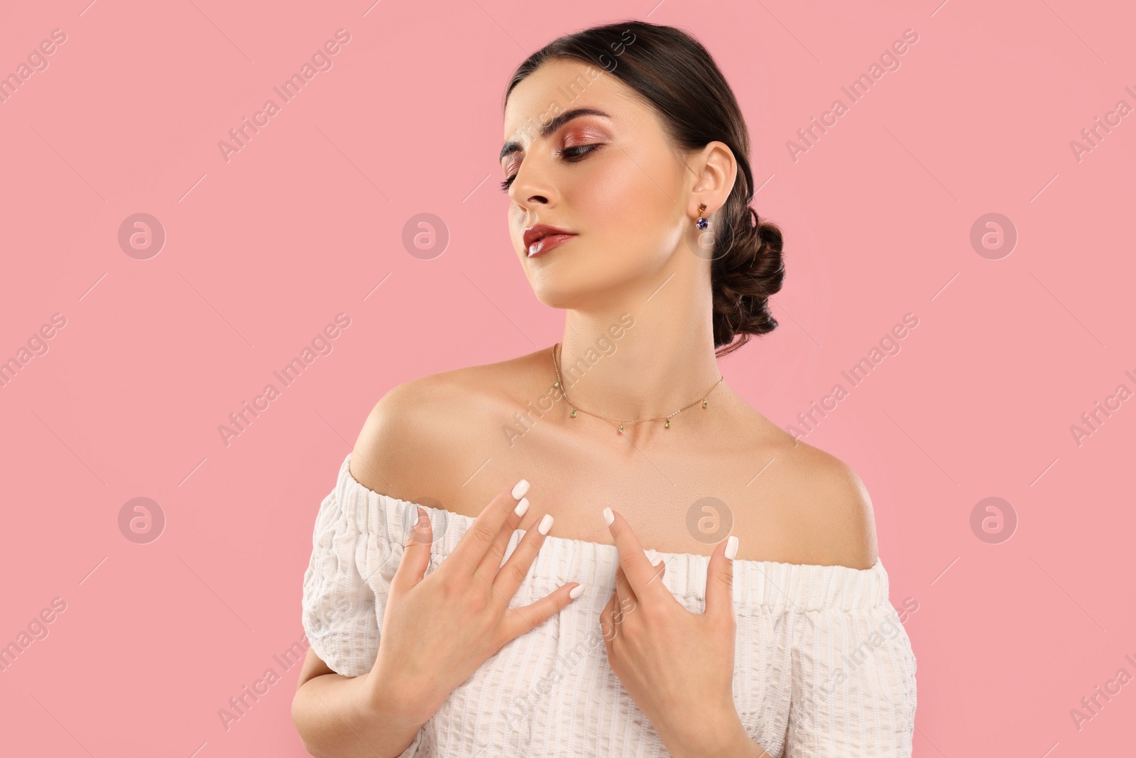 Photo of Beautiful woman with elegant jewelry on pink background