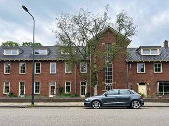 Beautiful view of city street with apartment building and parked car