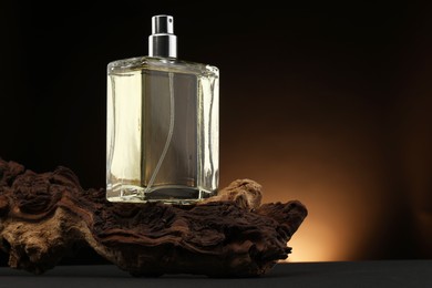 Luxury men`s perfume in bottle on grey table against dark background, space for text