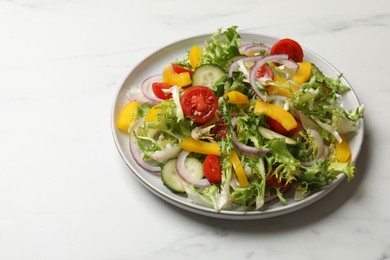 Photo of Tasty fresh vegetarian salad on white marble table, space for text